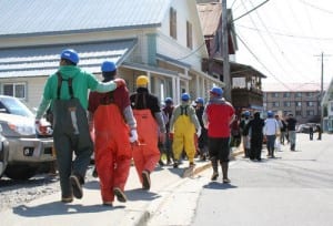 Workers from seafood processors near downtown Sitka walk down Katlian Street after being evacuated Monday morning. An ammonia leak from a tied-up vessel forced the closure of the road and the evacuation of nearby buildings. (KCAW photo by Erik Neumann)