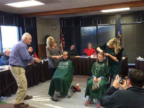 A well documented haircut: high school students Salma Zakiyah and Rosie Palof had their heads shaved as part of a fundraiser for the St. Baldrick's Foundation, at Tuesday night's meeting of the Sitka Assembly. (KCAW photo/Rachel Waldholz)