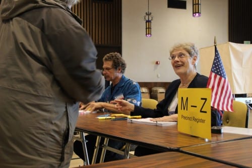 Poll worker Kathleen Brandt greets voters at primary day in Sitka's Harrigan Centennial Hall. (KCAW photo/Rachel Waldholz)