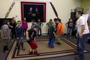 Chuck Miller, Youth Program Coordinator at the Sitka Native Education Program, teaches 2nd and 3rd graders a traditional Haida-style dance. The program is for kids from ages 3 to 18 from all different backgrounds who want to learn about the Tlingit culture. (Anne Brice/KCAW photo)