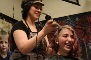 15-year-old Celia Lubin has her head shaved during the 2013 St. Baldrick's Fundraiser in Sitka. (KCAW photo/Rebecca LaGuire)