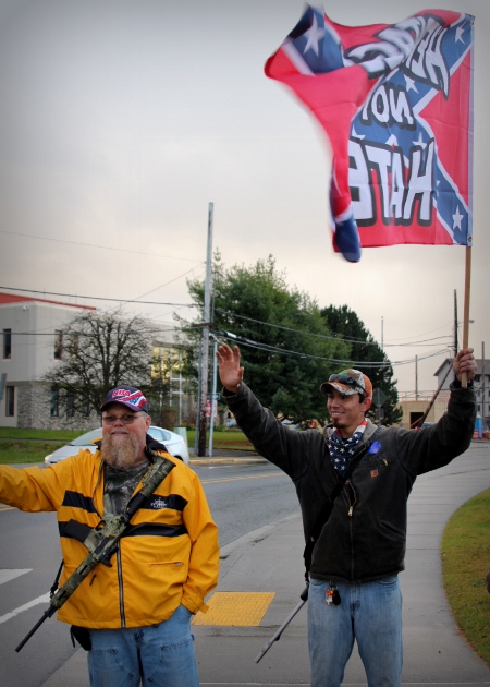 Marshall Albertson and Brittan Sheets, holding a Confederate flag that reads, 'Heritage not hate" march for the right to bear arms. (Emily Russell/KCAW Photo)