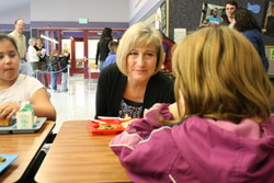 Alaska First Lady Sandy Parnell chats over a Fish -to-Schools lunch at Keet Gooshi Heen Elementary School in Sitka in April, 2012. (KCAW photo/Ed Ronco)
