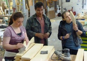 Doug Chilton works with students in a paddle-carving class.