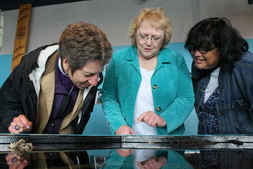 Episcopal Church Presiding Bishop Katharine Jefferts Schori, left, looks into a touch tank at the Sitka Sound Science Center with St. Peter's deacon Glenda Quintana, and interim rector Bishop Carol Gallagher. Jefferts Schori, a former oceanographer, has led the Episcopal Church since 2006. She's touring nine communities in Alaska. (KCAW photo by Ed Ronco)