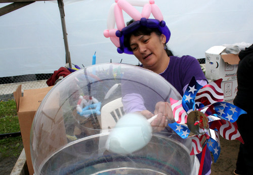 Jesse Notkong made cotton candy at Baranof playground during a rainy July 3rd afternoon. Food and game booths were set up for Sitka's Independence Day celebration. 