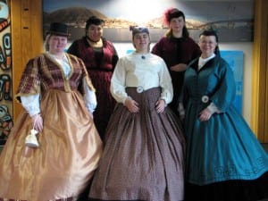 Alaska Day greeters in 1860s style attire at the Sitka airport. (KCAW photo by Emily Forman)