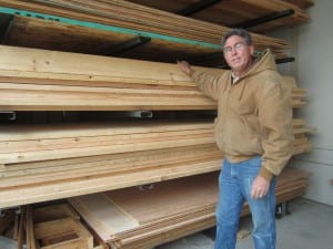 Randy Hughey inspects the spruce boards after they've been barged from Prince of Wales. (SCS photo)
