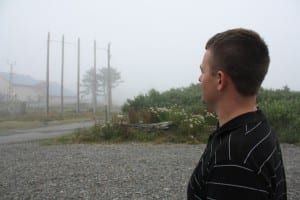Lt. Lance Leone looks at five power poles that once anchored electrical wires across a channel near La Push. A Coast Guard helicopter bearing Leone and three others hit the wires and crashed in 2010. Leone was the only survivor. (Photo: Ed Ronco/KPLU)