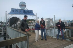Local officials hold a ribbon cutting to celebrated the completion of the ANB Harbor rebuild. (KCAW photo/Greta Mart)