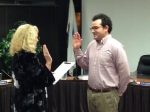 Colleen Ingman (l) administers the oath of office to new Assembly member Tristan Guevin. Another new assembly member, Steven Eisenbeisz, was out of town. (KCAW photo/Robert Woolsey)