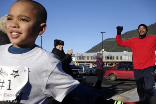 EJ Richards breaks through the streamers, while his father looks on. (Emily Kwong/KCAW photo)