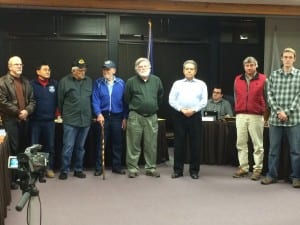 Veterans -- including city staff and two assembly members -- stood to be honored as Mayor Mim McConnell read a proclamation for Veterans Day. (KCAW photo/Rachel Waldholz)