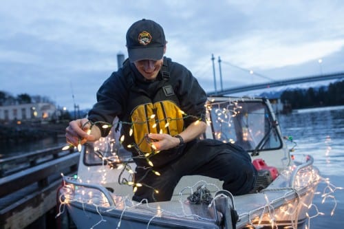 Paul Norwood strings lights aboard the Fucus. (Mike Hicks/KCAW photo)