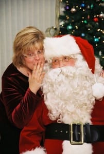Robb Farmer, as Santa, listens to a Christmas wish from his wife, Kathy.