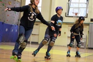 Sarah "Risky Mistress" Newhouse skates with Blatchley middle school students, during a roller derby unit earlier this spring.  (KCAW photo/Robert Woolsey)