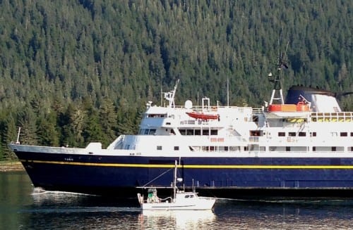 A Petersburg fishing boat passes the ferry Taku near the entrance of Wrangell Narrows in August, 2013. Budget cuts will take the ship out of service from July through September. (Photo by Ed Schoenfeld/CoastAlaska News)