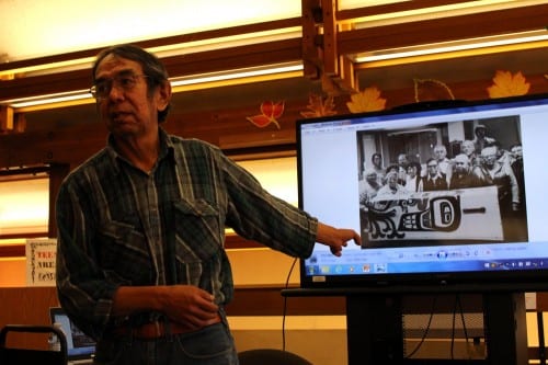 Sam gives a presentation at the library. He points to a picture of himself with Tlingit elders, who encouraged him to pursue his interest in cemetery caretaking. (Photo courtesy of Bob Sam) 
