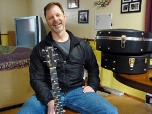 Juneau guitarist, singer and songwriter Kray Van Kirk talks about his music in his dining room. He'll perform during the Alaska Folk Festival, April 4-11 in Juneau. (Photo by Ed Schoenfeld/CoastAlaska News)