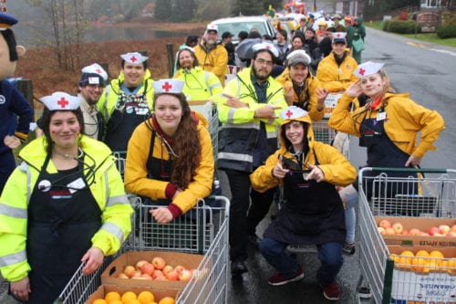 Employees from Seamart hand out apples and oranges at the 2016 Alaska Day parade. (KCAW Photo/Emily Russell)