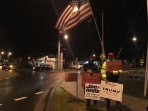 Ed Gray and Ralph Junker wave campaign signs in downtown Sitka on election day. (Emily Russell/KCAW Photo)