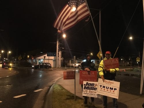 Ed Gray and Ralph Junker wave campaign signs in downtown Sitka on election day. (Emily Russell/KCAW Photo)