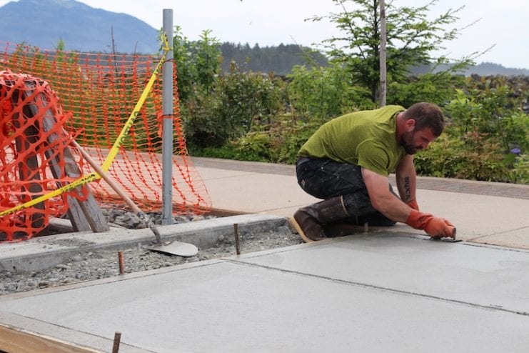 Mike Callahan finishes concrete in the play area.