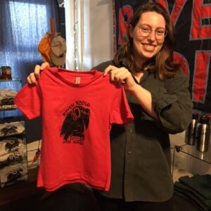 Photo of staff member holding a Red kids tee