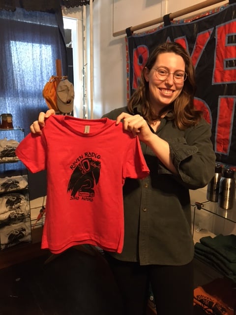 Photo of staff member holding a Red kids tee