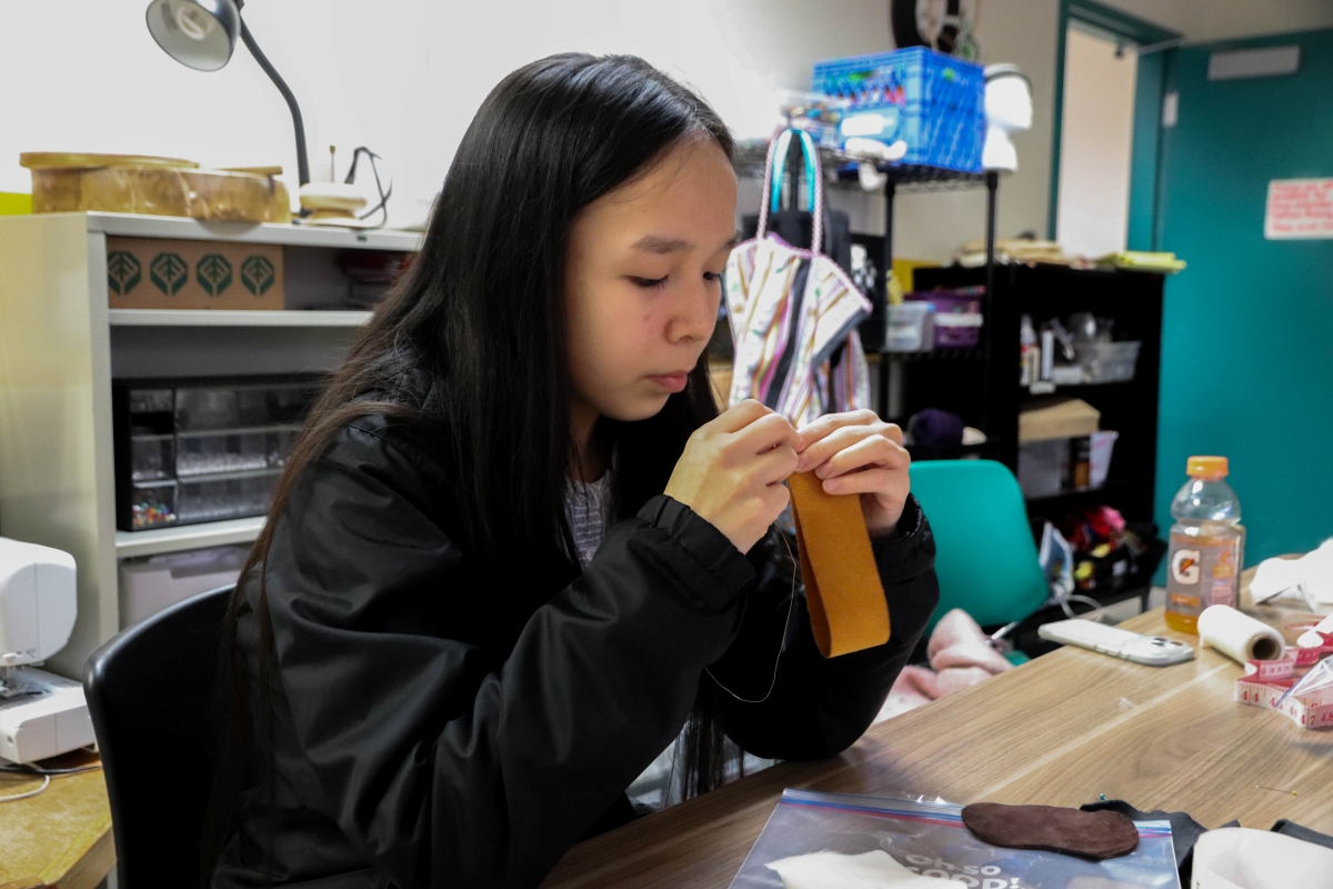 MEHS student Jubilee Lewis sews together a park of her leather baby boot (KCAW/Cotter)